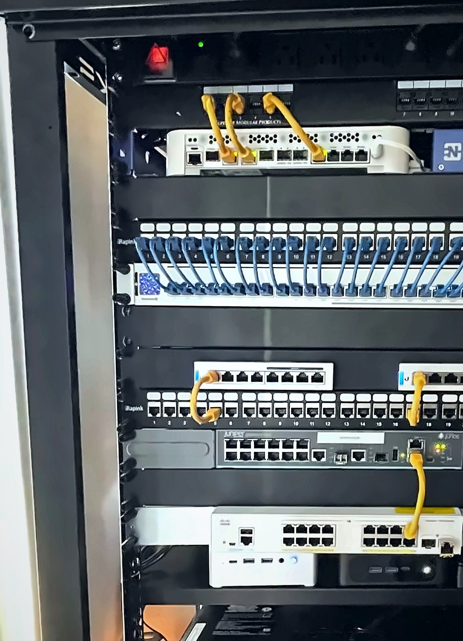 NETDZIN lab rack: firewall, managed switches, and patch panels.